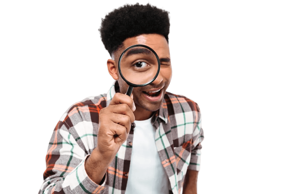 A young man peering through a magnifying glass